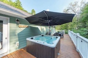 A hot tub on a wooden deck with a black umbrella overhead. - Cozy Cottage~Hot Tub+Fire Pit+Grill~WiFi~Near AVL! (Burnsville)