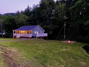 A house with a porch and a fire pit in the yard. - Cozy Cottage~Hot Tub+Fire Pit+Grill~WiFi~Near AVL! (Burnsville)