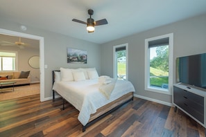 A bedroom with a bed, a ceiling fan, a TV, and a window. - Cozy Cottage~Hot Tub+Fire Pit+Grill~WiFi~Near AVL! (Burnsville)