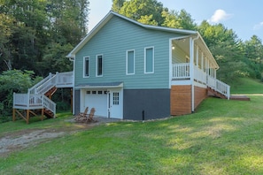 A two-story house with a front porch, a garage, and a deck.