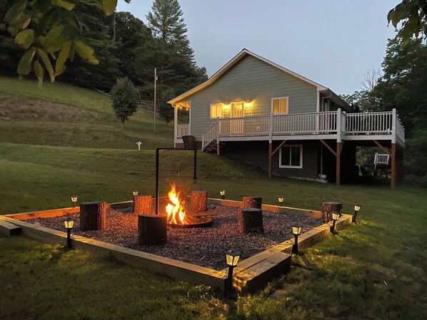 A house with a deck and a fire pit in the yard. - Cozy Cottage~Hot Tub+Fire Pit+Grill~WiFi~Near AVL! (Burnsville)