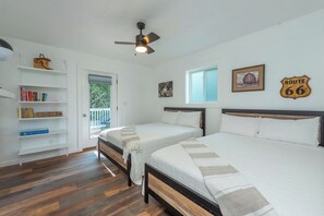 A bedroom with two beds, a ceiling fan, a bookshelf, and a window with a view. - Cozy Cottage~Hot Tub+Fire Pit+Grill~WiFi~Near AVL! (Burnsville)