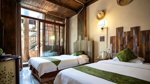 Habitación de hotel con dos camas, techo de madera, un reloj y vistas al exterior.