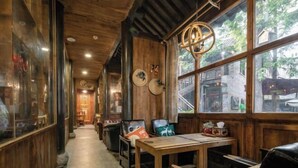 Un interior acogedor con paredes de madera, una mesa de madera y sillas de cuero.