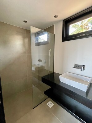 Een douche, handdoeken, zeep, toiletpapier