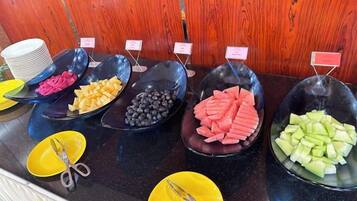 A buffet with various food items in black bowls, each labeled with a small sign.