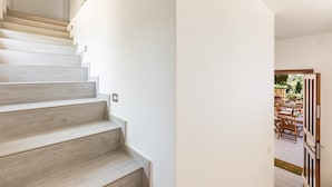 Una escalera conduce a una habitación con vistas a un patio al aire libre.