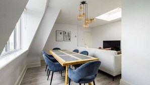 Ein modernes Schlafzimmer im Loft-Stil mit Essbereich, großen Fenstern und einem einzigartigen Deckenbau.