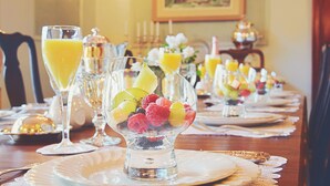 A dining table set with clear glass bowls containing fruit, accompanied by glasses of orange juice. - Manoir Chamberland (Adults Only, No Pets) (Montebello)