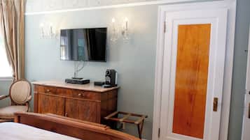 Un dormitorio con cama, cómoda de madera, televisor y puerta con panel de madera.