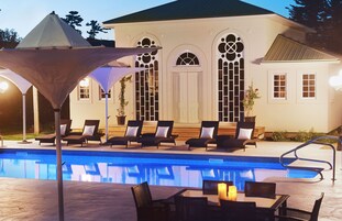 Una piscina al aire libre de temporada, sombrillas, tumbonas