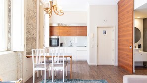 A modern kitchen with white cabinets, a wooden countertop, and a built-in oven.