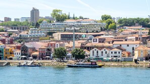 A riverside town with historic buildings, a dock with boats, and a clear sky. - Purple Oporto Home River Front - Ribeira (Vila Nova de Gaia)