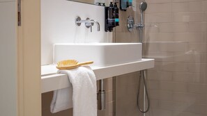 A bathroom with a white sink, a handheld showerhead, and a towel rack. - Purple Oporto Home River Front - Ribeira (Vila Nova de Gaia)