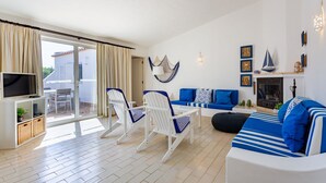 Uma sala de estar moderna com televisão, assentos e lareira.