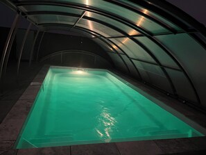 Uma piscina com estrutura de teto curva.