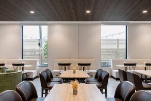 Un comedor moderno con una mesa larga, varias sillas y un sofá.