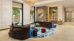 A modern lobby with a unique seating area, a large clock, and a display of snacks. - Fairfield by Marriott Mumbai International Airport (Mumbai)
