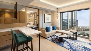 A modern living room with a sofa, a dining area, and a large window offering a city view. - Fairfield by Marriott Mumbai International Airport (Mumbai)