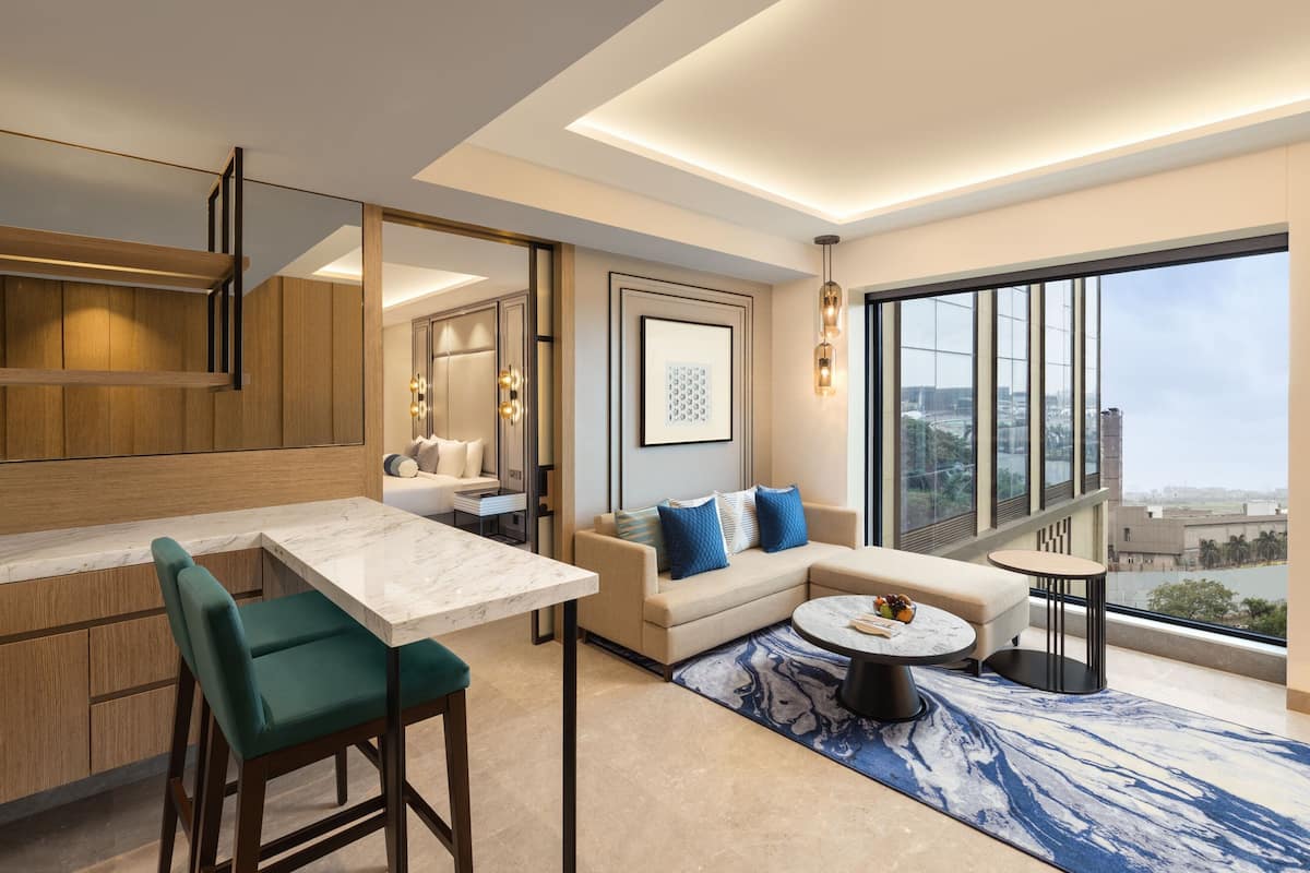 Ein modernes Wohnzimmer mit Sofa, Esstisch und Blick auf die Stadt.