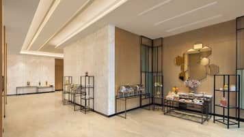 Una hall d'albergo moderna con pavimenti in marmo, postazioni per il buffet e arredamento contemporaneo.