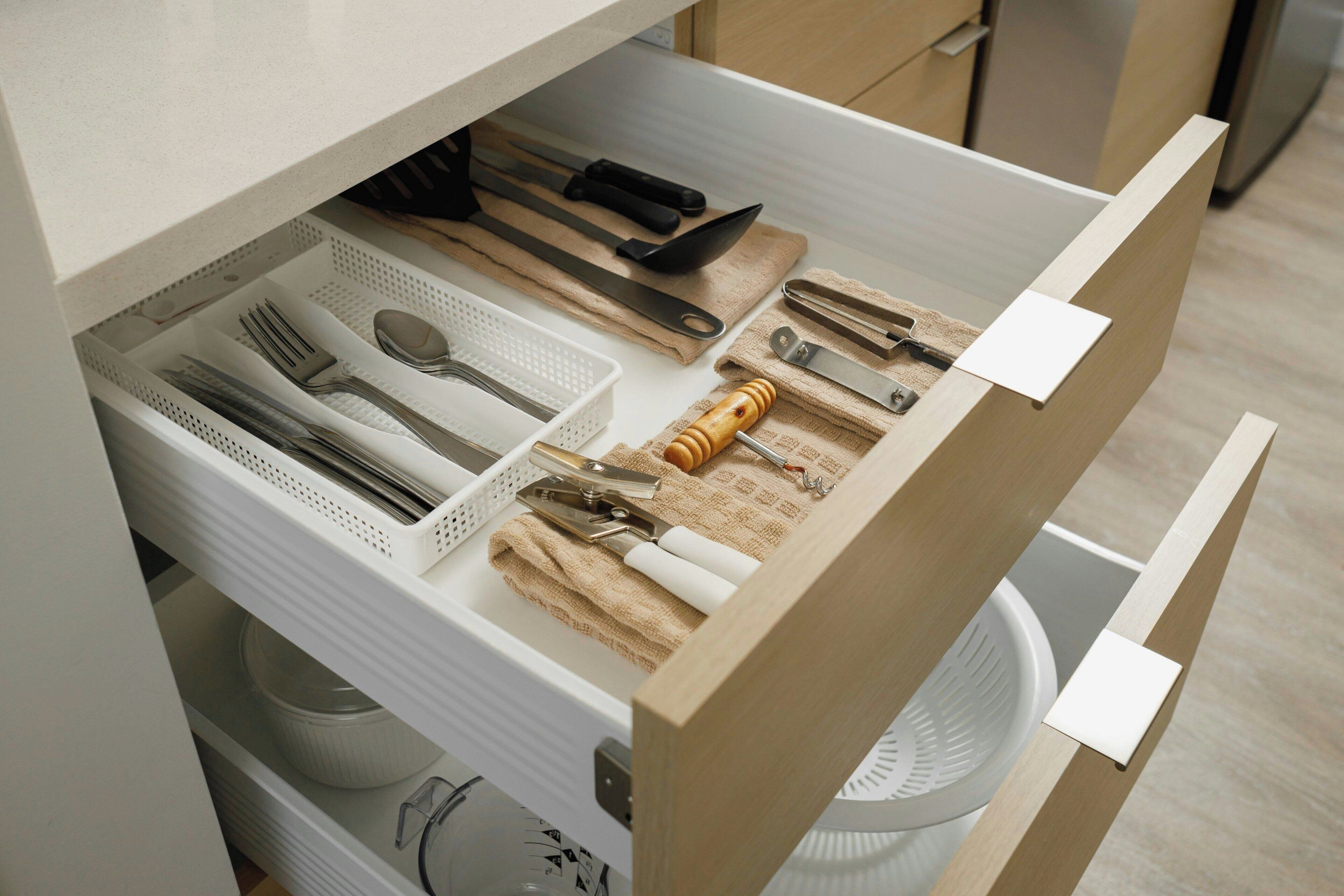 Un cassetto della cucina con utensili e pentole.