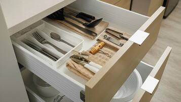 Un cassetto della cucina con utensili e pentole.