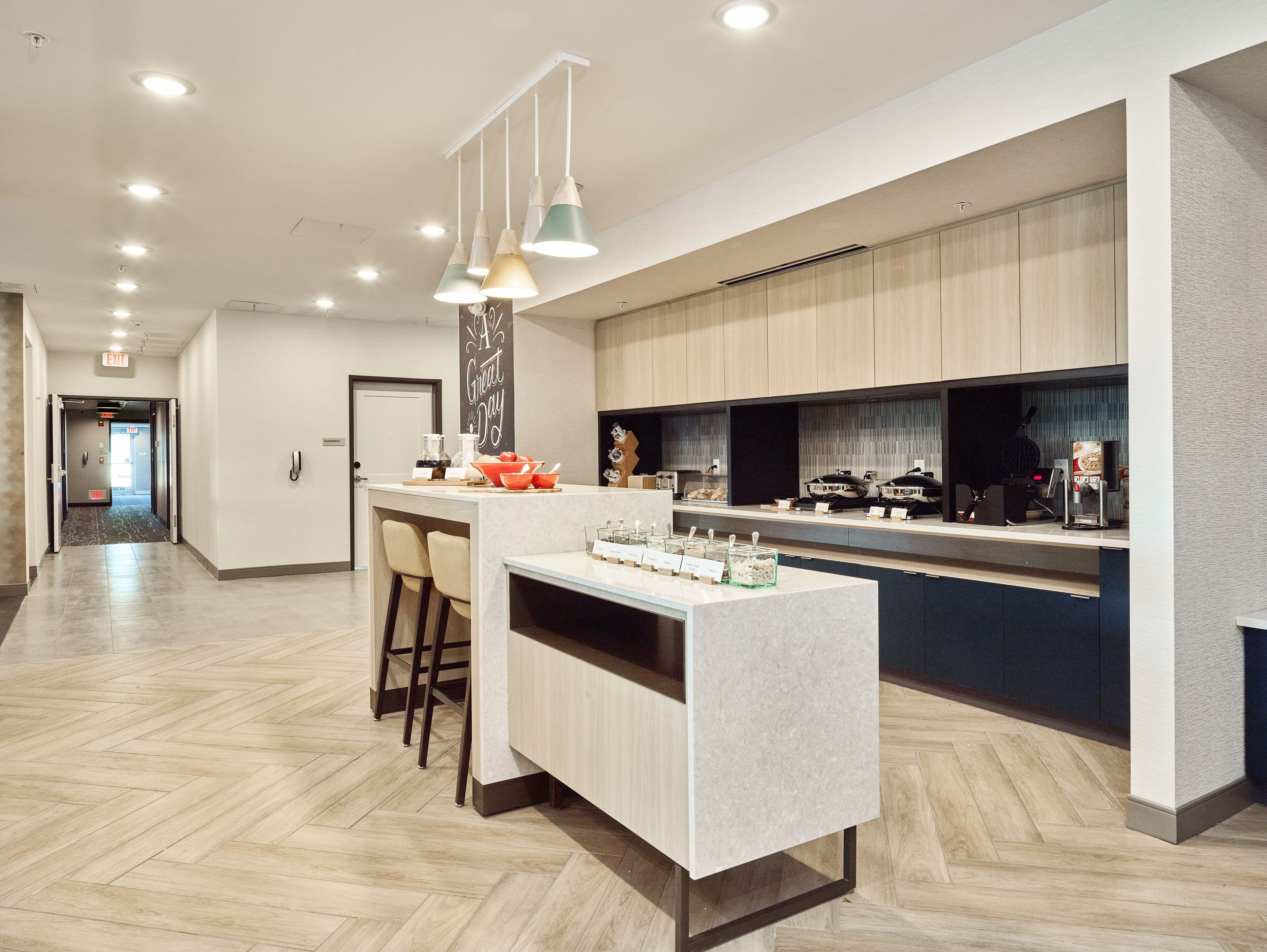 A modern kitchen with a central island, bar stools, and a breakfast bar.