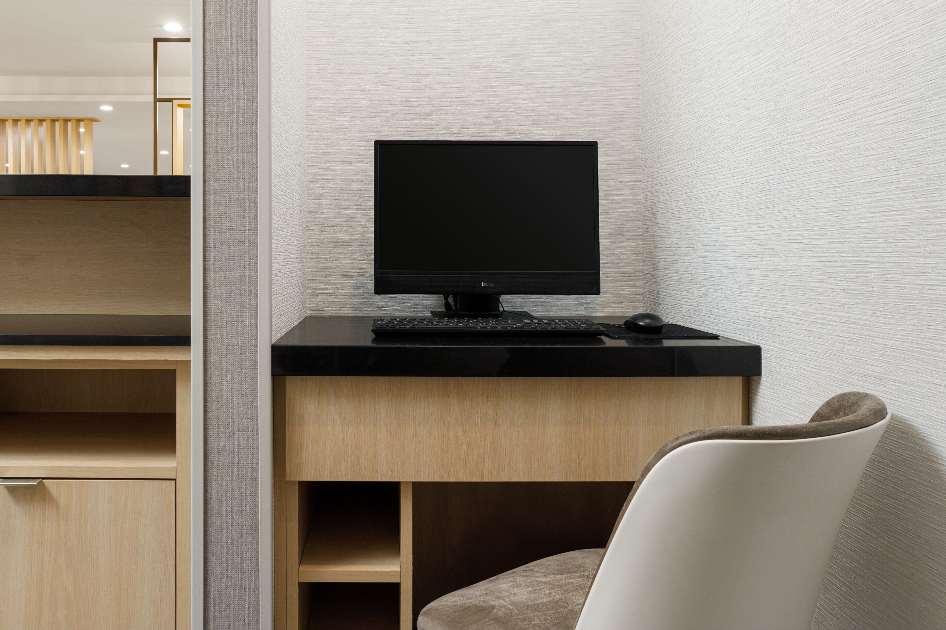 A modern office desk with a computer, keyboard, and mouse.