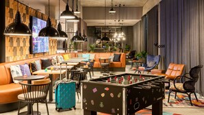 Un área de lounge moderna con mesa de fútbol, asientos cómodos e iluminación ambiental.