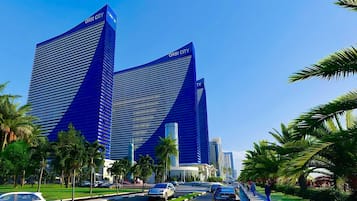 Two high-rise buildings with 'ORBI CITY' signage, surrounded by palm trees and a well-maintained urban street.