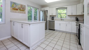 A kitchen with white cabinets, a refrigerator, a dishwasher, and a coffee maker. - Family Friendly, Great Pool and Easy Bowman's Beach Access (Sanibel)