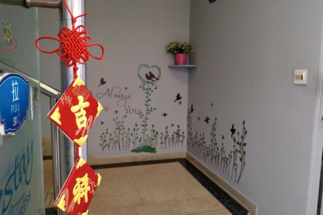 A hallway with a blue sign, a red and gold decoration, and a wall with floral and butterfly decals.