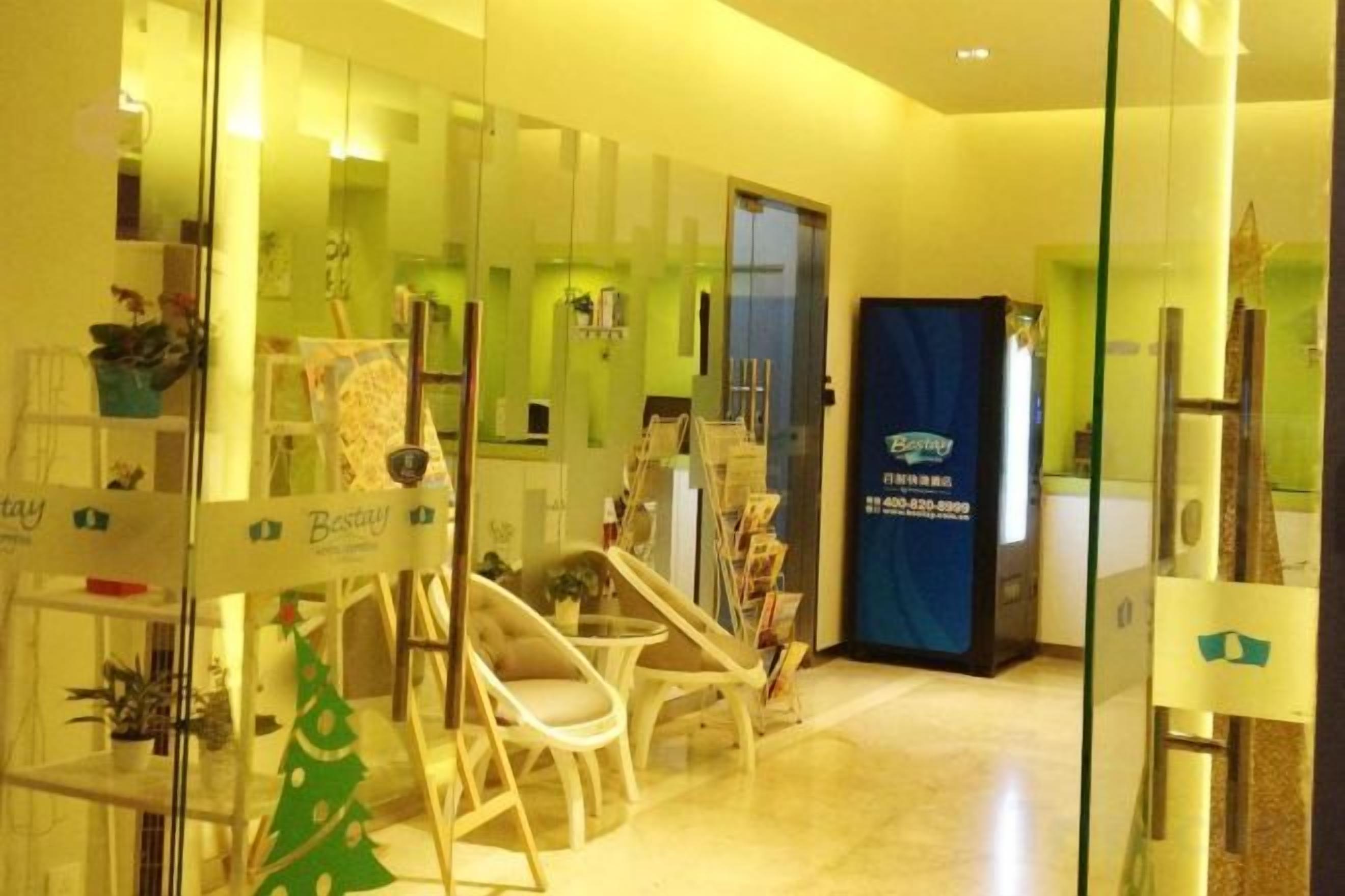 A reception area with a glass partition, reception desk, and seating area with chairs.