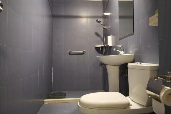 A bathroom with a toilet, sink, and shower. - Baishijie Hotel (Shantou)