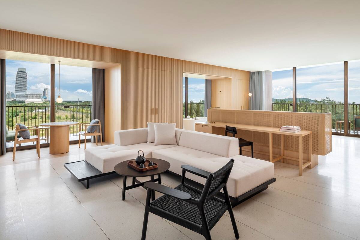 A modern living room with a sofa, coffee table, and a desk area.