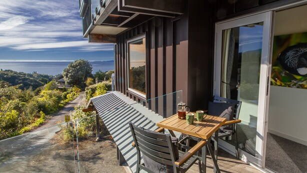 Een modern terras met een tafel en stoelen, met uitzicht op een prachtig landschap.