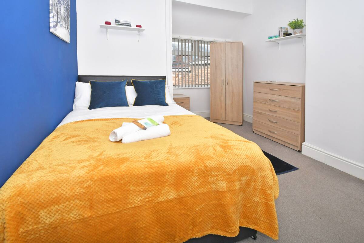 Une chambre bien rangée, avec un lit, une armoire et une petite table de chevet.