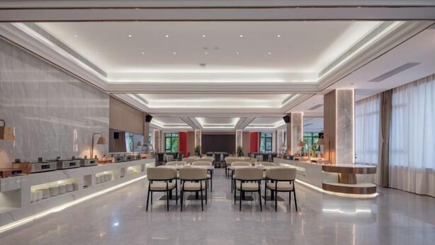 Eine geräumige Lobby mit modernem Design, ausgestattet mit einer zentralen Sitzecke, einer Rezeption und großen Fenstern für natürliches Licht.