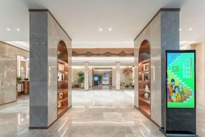 A hotel lobby with marble flooring, a reception desk, and a digital information kiosk. - Yichang Xiazhou Yiling Hotel (Jiefang Road Pedestrian Street, Yanjiang Avenue) (Yichang)