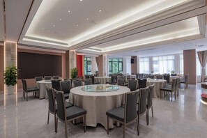 A spacious conference room with round tables and chairs, large windows, and a modern ceiling design. - Yichang Xiazhou Yiling Hotel (Jiefang Road Pedestrian Street, Yanjiang Avenue) (Yichang)