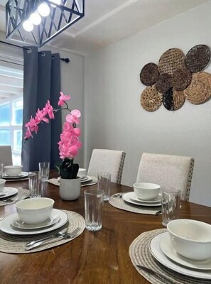 Enjoy a meal in this inviting dining area with a beautifully set table and comfortable seating.