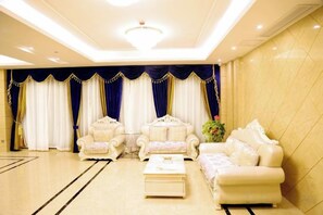 A spacious lobby with a high ceiling, elegant seating arrangements, and a chandelier. - Ruju Business Hotel (Wuhu)
