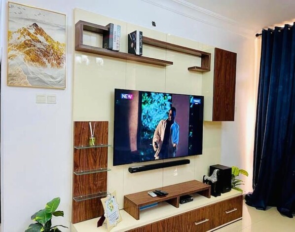 Ein modernes Wohnzimmer mit einem Flachbildfernseher, der an einer Holztruhe befestigt ist.