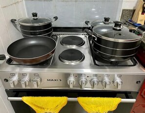 Eine Küche mit Herd, Töpfen und Pfannen.