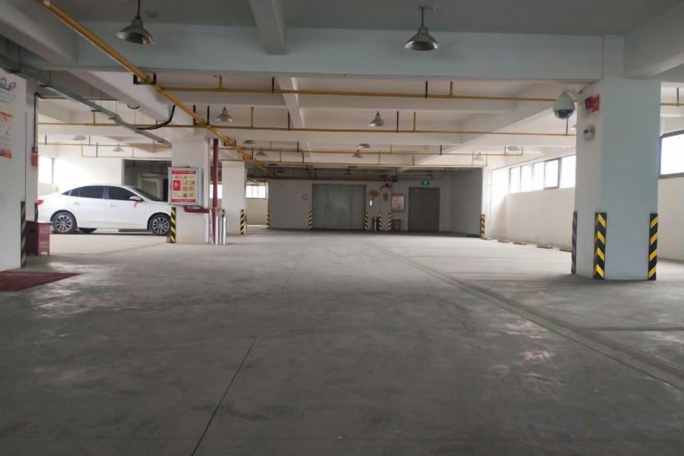 Un parking souterrain vide, avec plusieurs niveaux, des planchers en béton et des piliers de soutien.