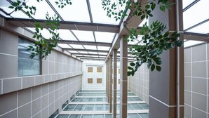 A modern interior corridor with glass flooring, tiled walls, and a skylight. - Qingtian Boutique Hotel (Zhaotong Fengxia Road) (Zhaotong)