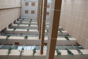 A multi-level interior with tiled walls, a central staircase, and greenery on the steps.