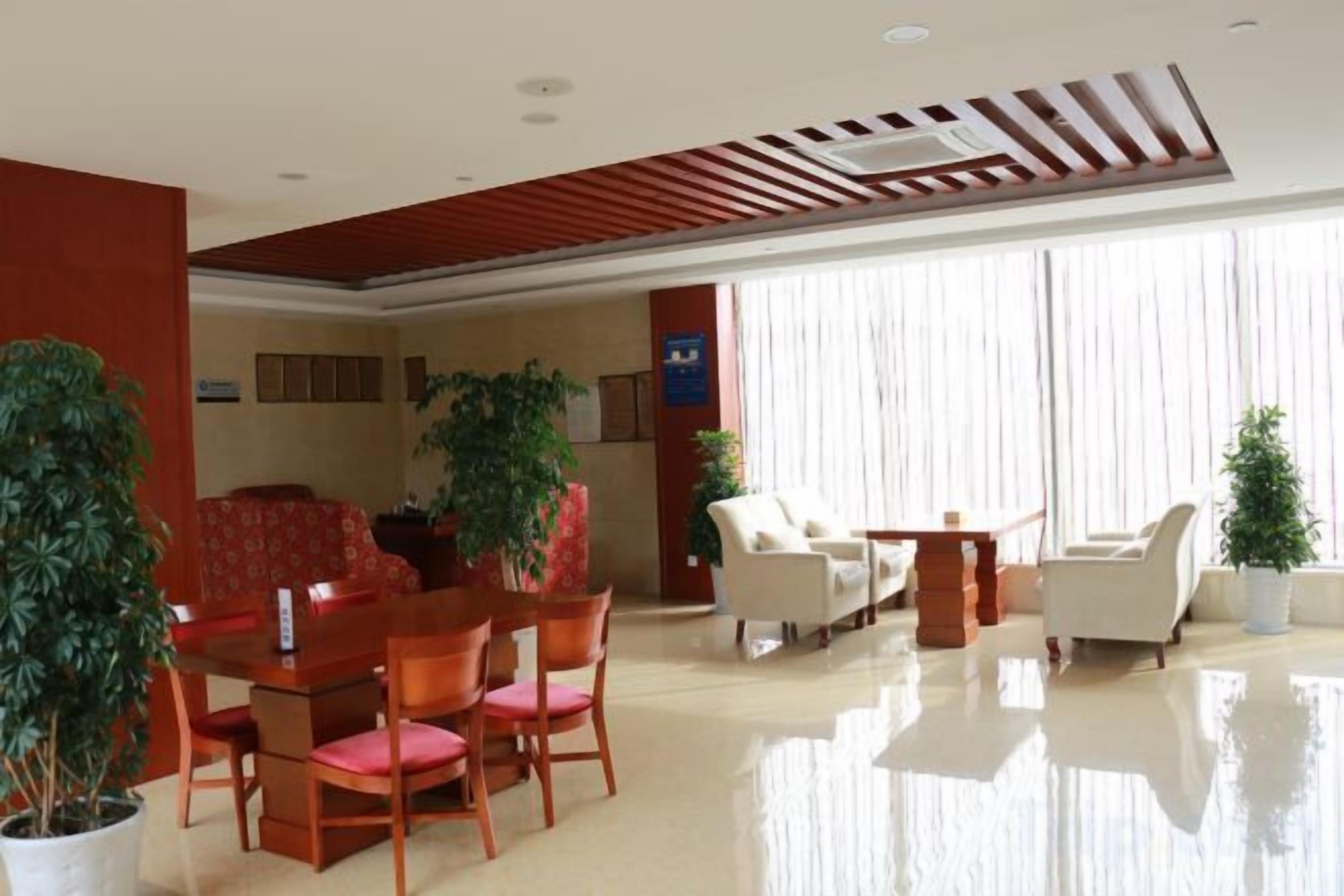 Et hotellobby med spiseområde, siddepladser og store vinduer.
