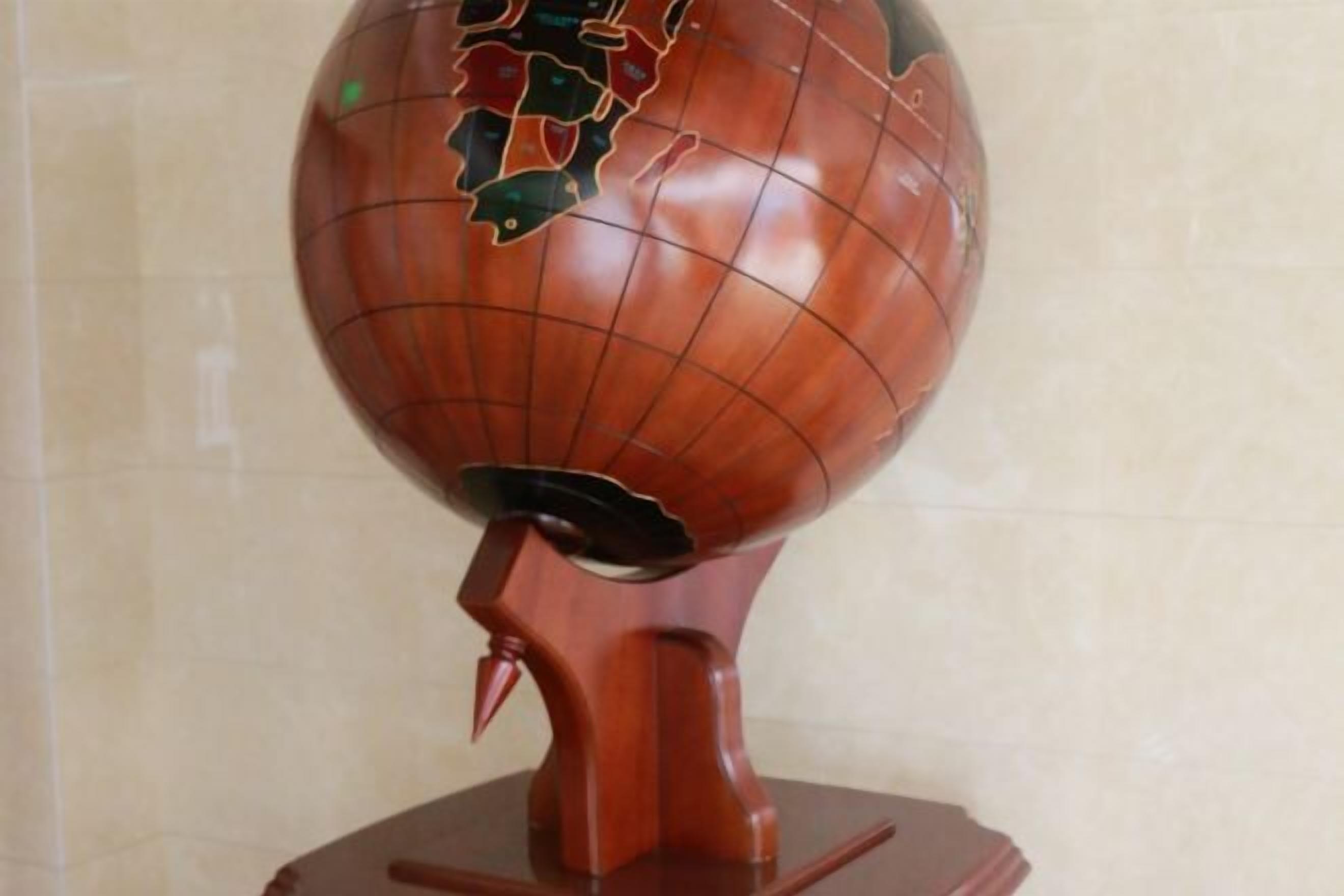 A wooden globe with a cracked surface, mounted on a stand.